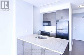 Toronto (Henry Farm) condo for rent - A kitchen with a granite countertop and a refrigerator.