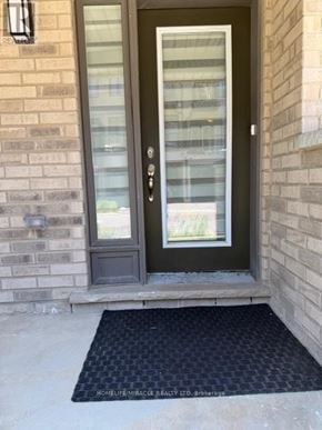 Brantford townhouse for rent - A black door with a glass panel and a black mat in front of it.