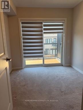 Brantford townhouse for rent - A room with a sliding door leading to a balcony.