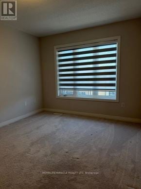 Brantford townhouse for rent - A room with a window covered by horizontal blinds.