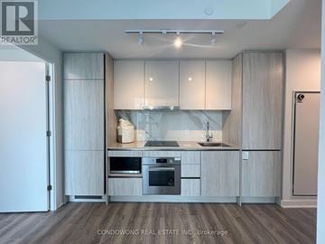 Toronto (Moss Park) condo for rent - A modern kitchen with wooden cabinets and stainless steel appliances.