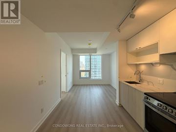 Toronto (Church-Yonge Corridor) condo for rent - A kitchen with white cabinets and a black stove top oven.