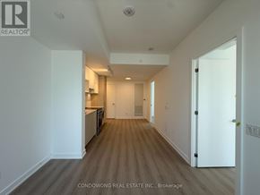 Toronto (Church-Yonge Corridor) condo for rent - A long hallway with a kitchen area on the left and a door on the right.