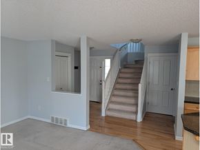 Edmonton apartment for rent - A white staircase with a light grey wall and a window with white blinds.