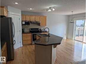 Edmonton apartment for rent - A kitchen with wooden cabinets and a black countertop.