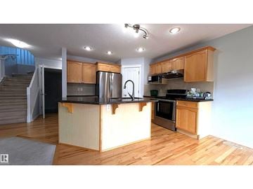 Edmonton apartment for rent - A kitchen with wooden cabinets and a black countertop.