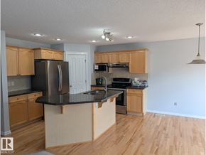 Edmonton apartment for rent - A kitchen with a black countertop and wooden cabinets.