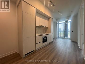 Toronto (Moss Park) condo for rent - A kitchen with white cabinets and a wooden floor.