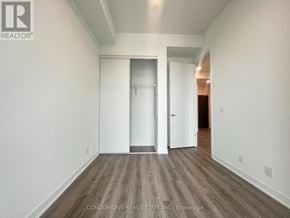 Toronto (Moss Park) condo for rent - A hallway with wood flooring and white walls.