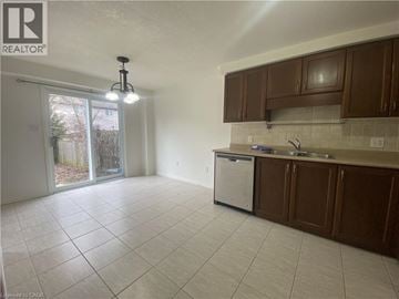 Waterloo townhouse for rent - A kitchen with brown cabinets and a white dishwasher.