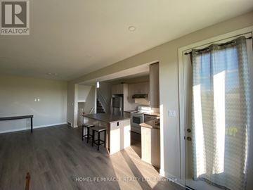 London North (North M) apartment for rent - A well-lit kitchen with a dining table and chairs is visible from the living room.