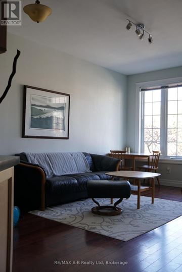 Kitchener townhouse for rent - A living room with a black leather couch and a framed picture on the wall.