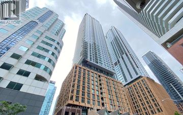 Toronto (Waterfront Communities) condo for rent - A tall building with the words "HOMELIFE/MIRACLE" on it stands among other skyscrapers.