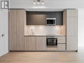 Toronto (Waterfront Communities) condo for rent - A modern kitchen with wooden cabinets and stainless steel appliances.