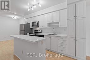 Toronto (Waterfront Communities) condo for rent - A white kitchen with a refrigerator, microwave, and sink.