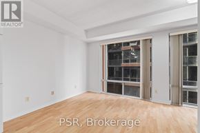 Toronto (Waterfront Communities) condo for rent - A room with wooden flooring and white walls, with a large window and a door leading to a balcony.