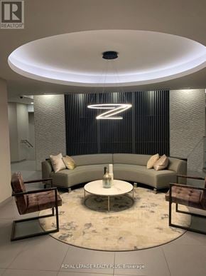 Burlington (Lasalle) condo for rent - A modern living room with a large circular table and a couch with a backdrop of a large letter Z.