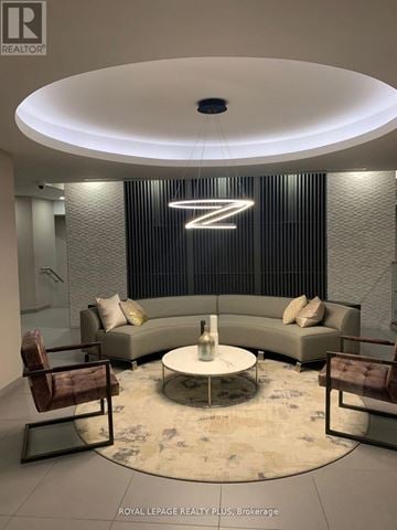 Burlington (Lasalle) condo for rent - A modern living room with a large circular table and a couch with a backdrop of a large letter Z.