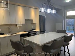 Burlington (Lasalle) condo for rent - A kitchen with a table and chairs in front of a window.
