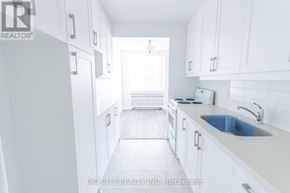Toronto (St. Andrew-Windfields) condo for rent - A white kitchen with a sink and a window.