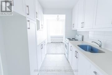 Toronto (St. Andrew-Windfields) condo for rent - A white kitchen with a sink and a window.