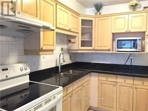 Toronto (Agincourt South-Malvern West) condo for rent - A kitchen with wooden cabinets and a black countertop.
