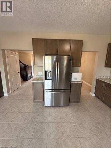 Hamilton apartment for rent - A kitchen with a stainless steel refrigerator and a tiled floor.