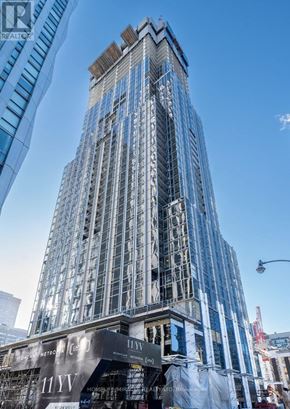 Toronto (Annex) condo for rent - A tall building under construction with a sign that reads "11WY".
