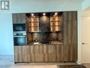 Toronto (Annex) condo for rent - A modern kitchen with a stainless steel refrigerator and wooden cabinets.