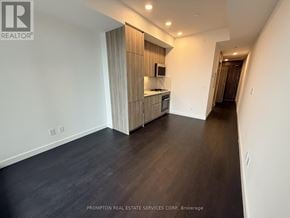 Toronto (Bayview Village) condo for rent - A spacious room with a kitchen area and a hallway.