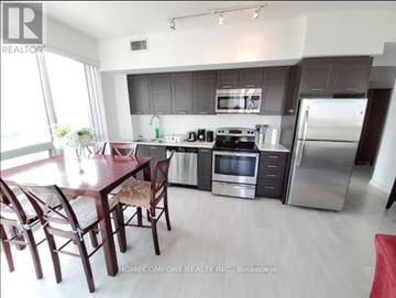Toronto (Mimico) condo for rent - A kitchen with a table and chairs in front of a refrigerator.