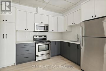 Fort Erie (Central) condo for rent - A kitchen with white cabinets and a stainless steel refrigerator.