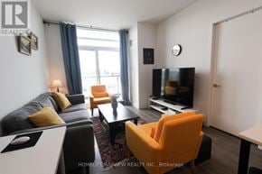 Vaughan (Beverley Glen) condo for rent - A living room with a grey couch, orange armchair, and a black television.