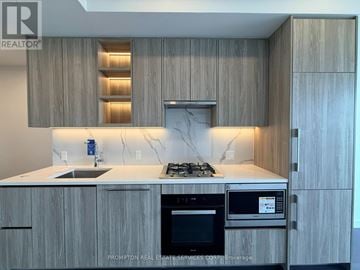 Toronto (Bayview Village) condo for rent - A kitchen with a stove top oven and microwave.