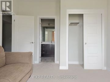 Hamilton (Fruitland) townhouse for rent - A living room with a couch and a doorway leading to a kitchen.