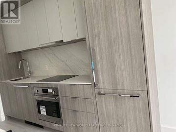 Toronto (Bayview Village) condo for rent - A modern kitchen with a stainless steel oven and a wooden cabinet.