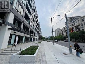 Toronto (Bayview Village) condo for rent - A woman is walking down a sidewalk in front of a building with a sign that says "REALTOR".