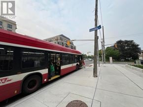 Toronto (Bayview Village) condo for rent - A red and white bus is parked on the side of the road.