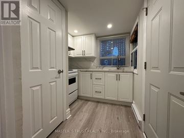 Toronto (Caledonia-Fairbank) apartment for rent - A white kitchen with a wooden floor and cabinets.