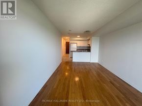 Richmond Hill (Langstaff) condo for rent - A long, empty hallway with wooden floors and white walls.