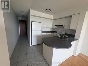 Richmond Hill (Langstaff) condo for rent - A kitchen with white cabinets and a black countertop.