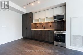 Toronto (Waterfront Communities) condo for rent - A modern kitchen with dark wood cabinets and stainless steel appliances.