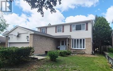 Newmarket (Huron Heights-Leslie Valley) apartment for rent - A house with a white door and windows is surrounded by greenery.