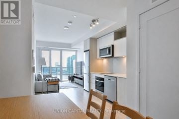 Toronto (Moss Park) condo for rent - A modern kitchen with a dining table and chairs.