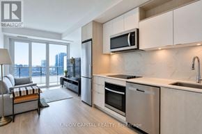 Toronto (Moss Park) condo for rent - A modern kitchen with stainless steel appliances and wooden flooring.
