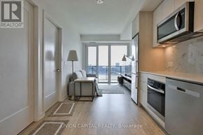 Toronto (Moss Park) condo for rent - A modern kitchen with Union Capital Realty logo on the wall.