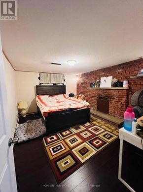 Richmond Hill (Crosby) apartment for rent - A bedroom with a brick wall and a bed with a white and red comforter.