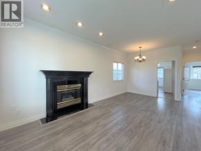 Vancouver apartment for rent - A spacious room with a fireplace and wood flooring.