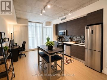 Toronto (Waterfront Communities) condo for rent - A modern kitchen with a dining table and chairs.