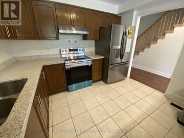 Whitby (Taunton North) townhouse for rent - A kitchen with a stove top oven and a refrigerator.